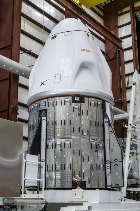 a white space capsule with metallic bottom trunk in a bright hangar.