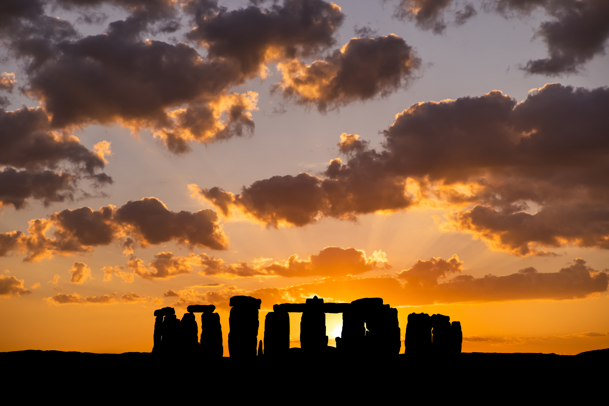 The sun sets behind Stonehenge.