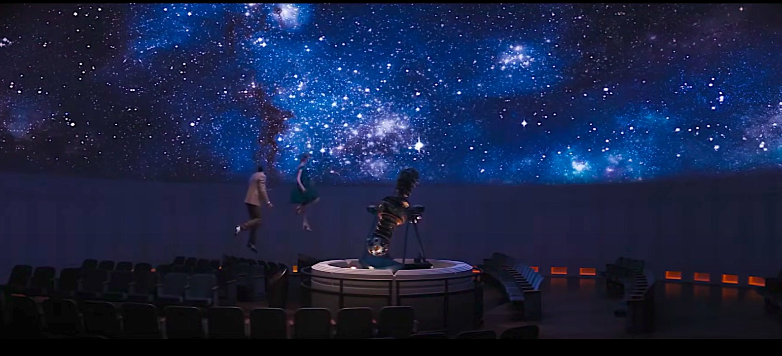 Two people float up into a star-filled planetarium screen