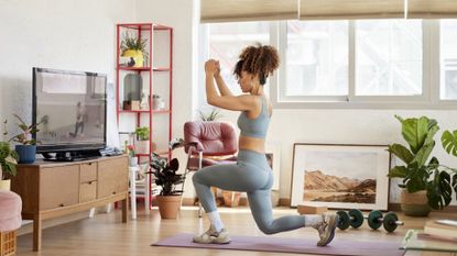 Woman performs lunges on a yoga mat at home