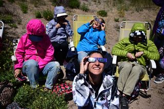 People watch the total solar eclipse in Piedra del Aguila, Neuquen province, Argentina on December 14, 2020.