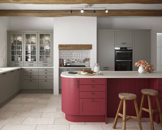 red cabinets in a rounded edge island in a country style kitchen with grey cabinets in a country home with beams