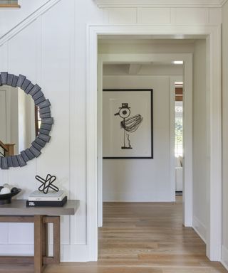 White entryway with gray circular mirror