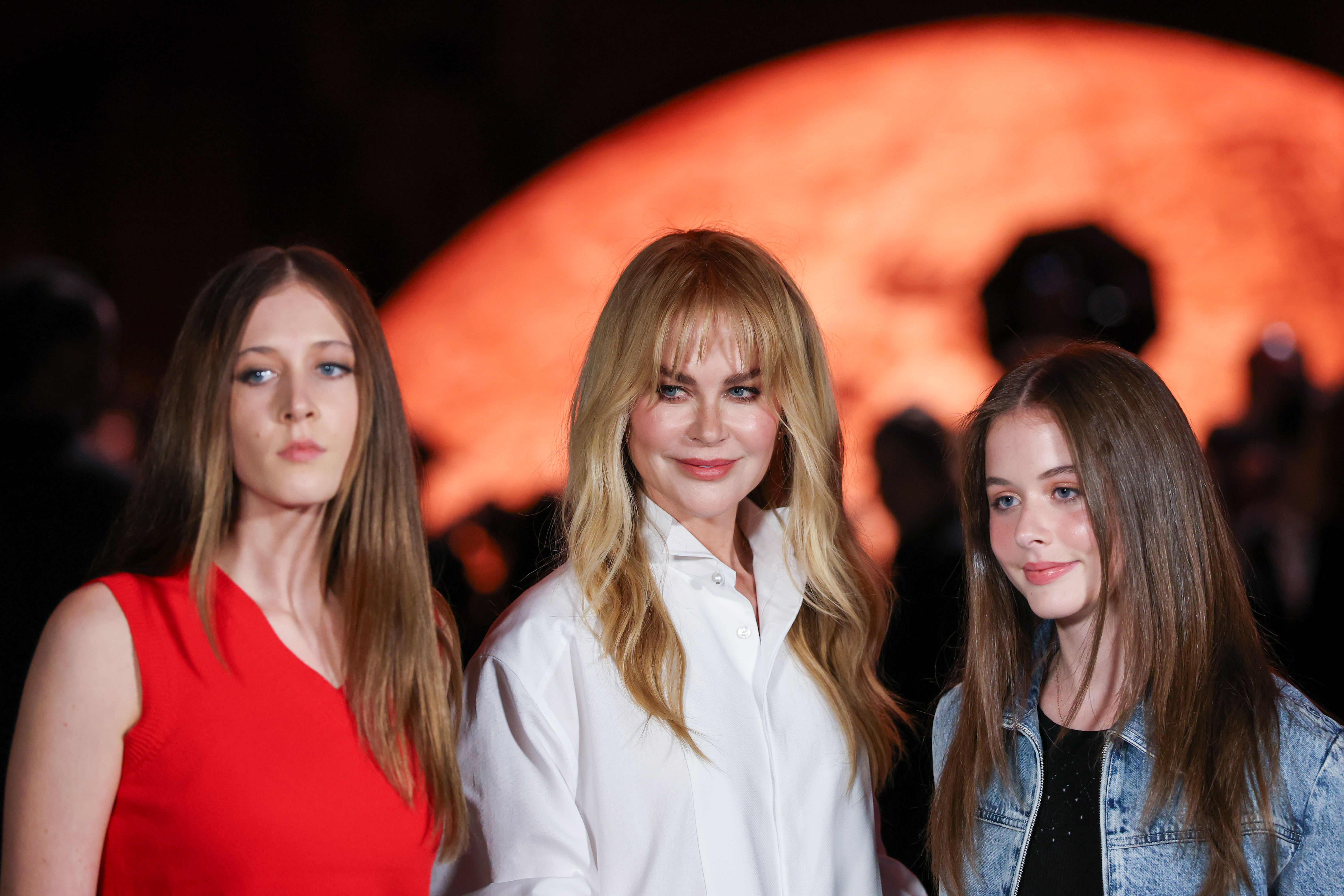 three white women wearing a red top, white shirt, and denim jacket