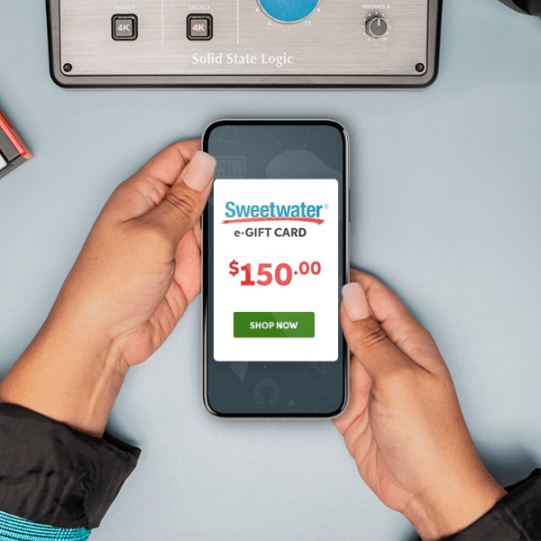 A woman holds a smartphone with a Sweetwater gift card on the screen