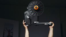 Elite Rivo with Zwift Cog and Click being held aloft by two hands