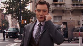 Chuck in animal print walking around New York while talking on the phone.