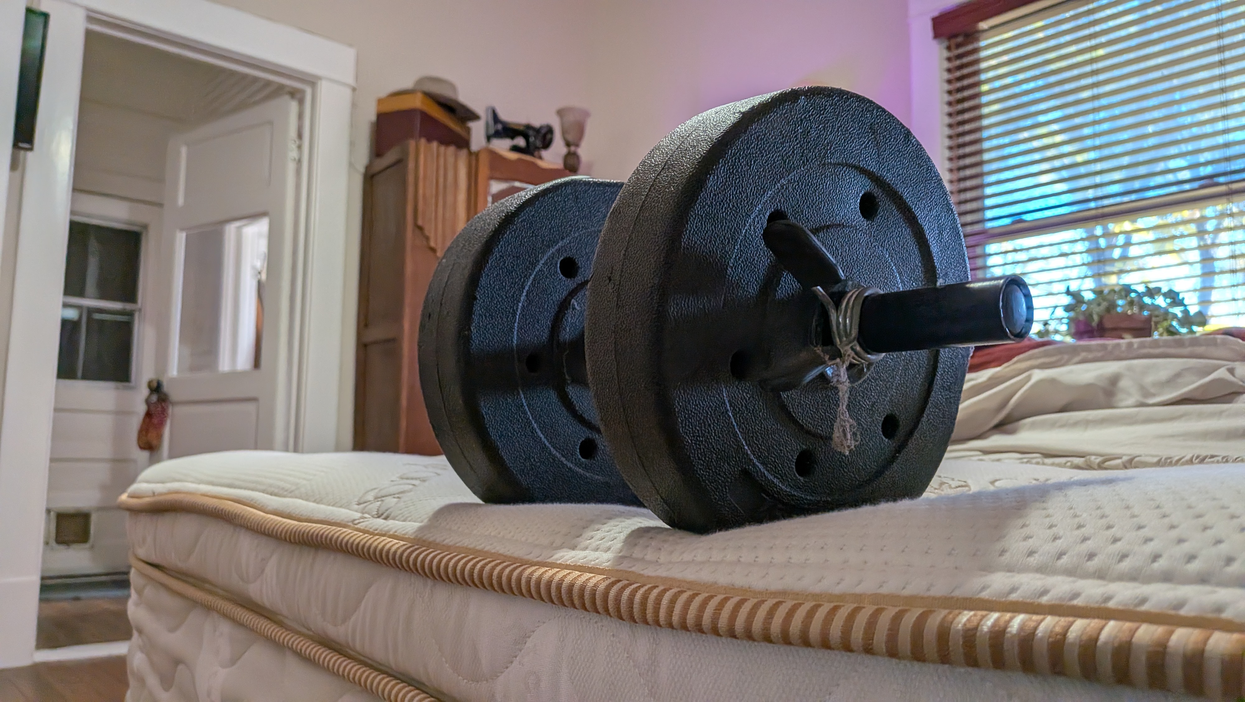 A 15lb dumbbell on the foot of the Saatva Latex Hybrid Mattress to test its edge support