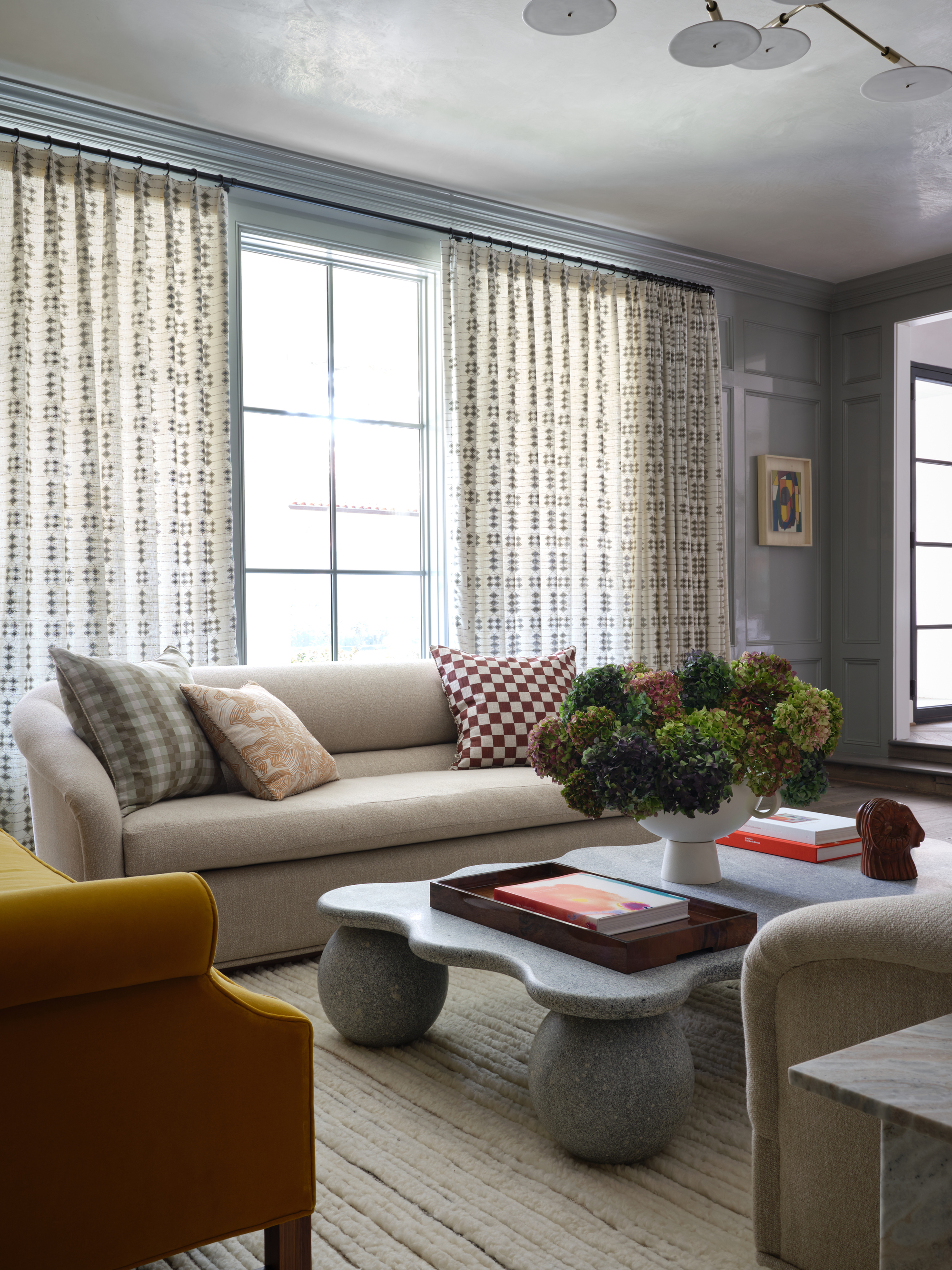 living room with couches, a coffee table, and window coverings