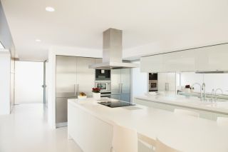 white kitchen with island and chrome extractor fan