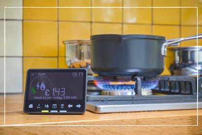 saucepan on lit gas stove with a smart energy meter next to it on a kitchen counter