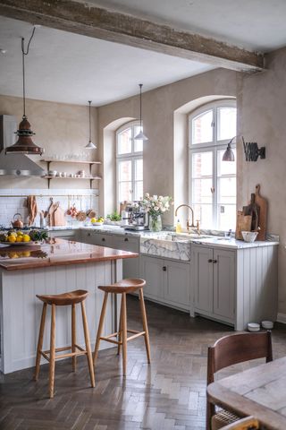 a tall kitchen with pendant lights hanging over the countertop and island