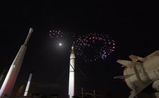 NASA rockets in front of a night sky with fireworks