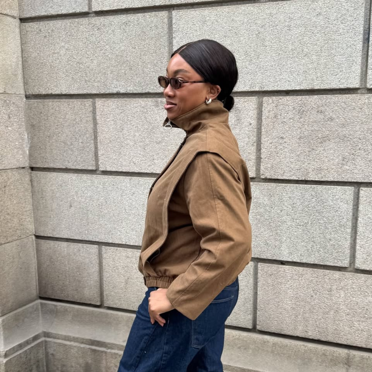 Nnenna in funnel-neck jacket and dark-wash denim