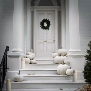 A front door decorated for Halloween in white