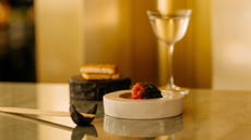 A wide shot image of tuna tartare with caviar and a glass of sake in the background