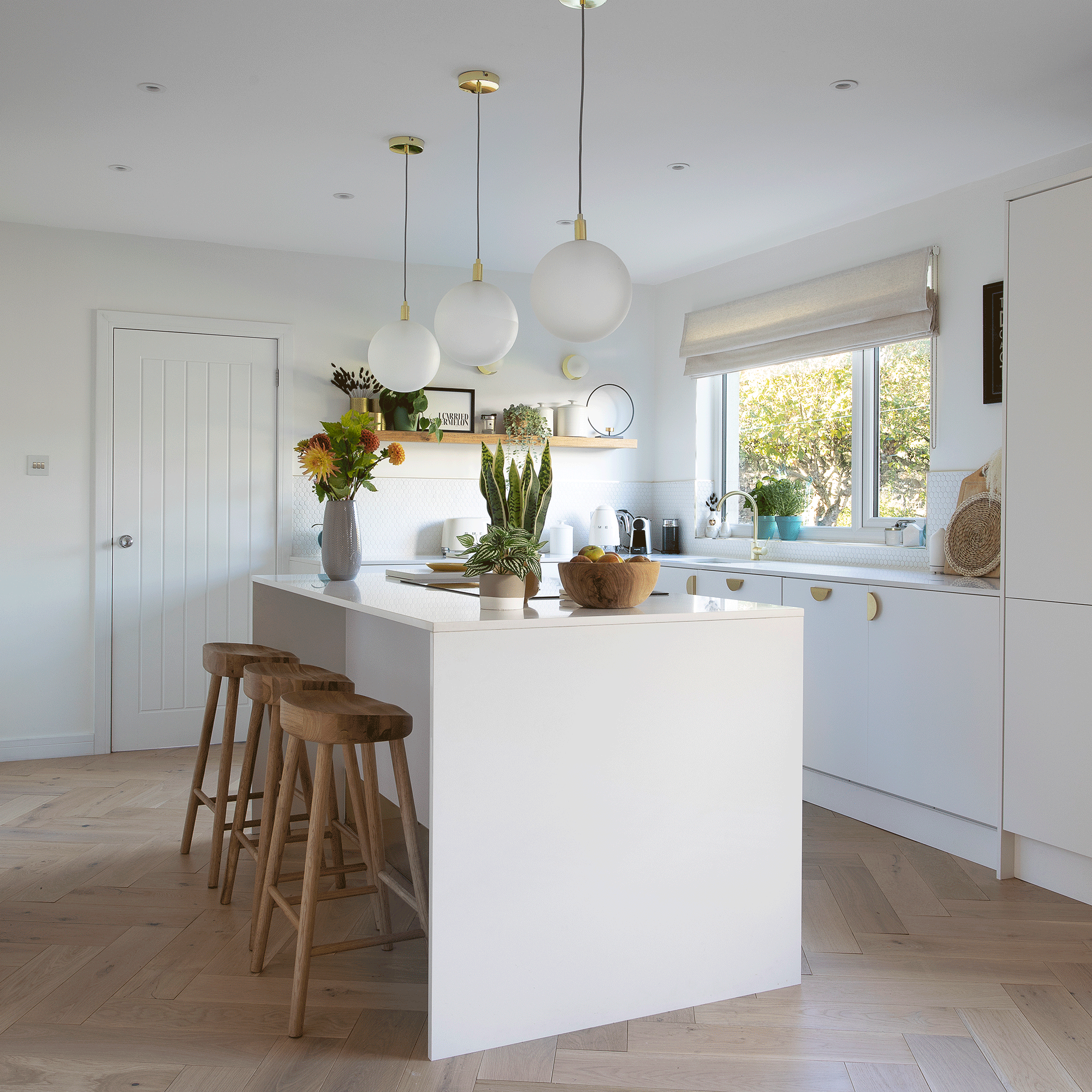 White kitchen with island and wooden stools