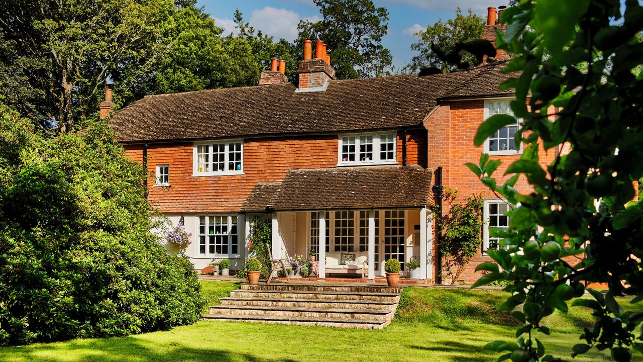 Back garden with house exterior, lawn, greenery