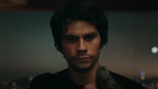 Dylan O'Brien as Mitch Rapp holding a pistol in American Assassin