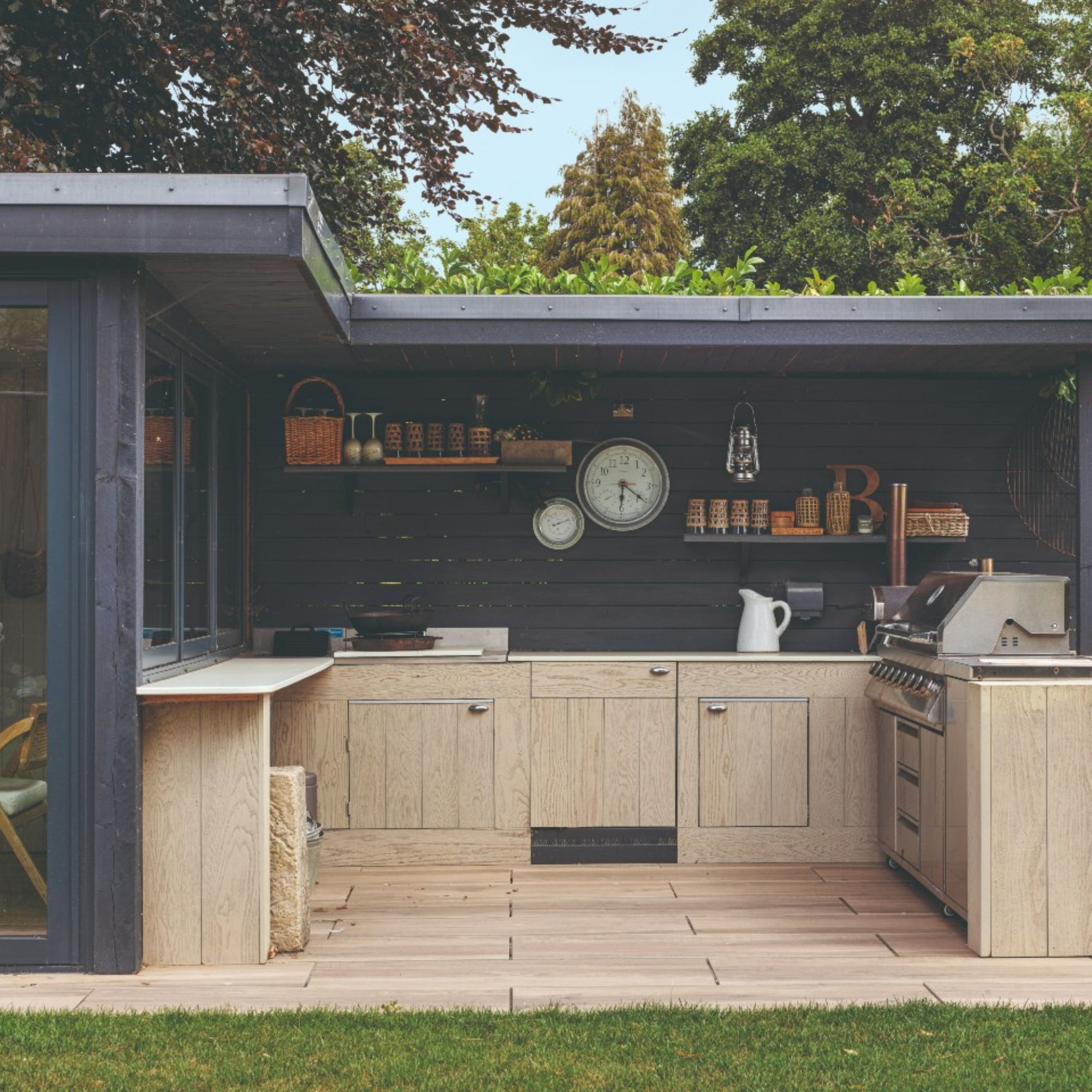 Garden kitchen painted in navy with light wood cabinetry