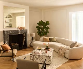 retro living room with curved statement sofa and marble effect coffee table with retro armchairs
