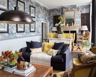 Long living room idea with blue patterned wallpaper and furniture away from walls.
