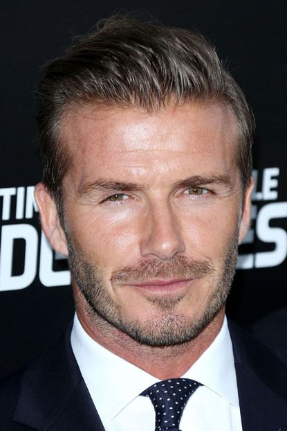 David beckham wears a black suit and tie at a London premiere