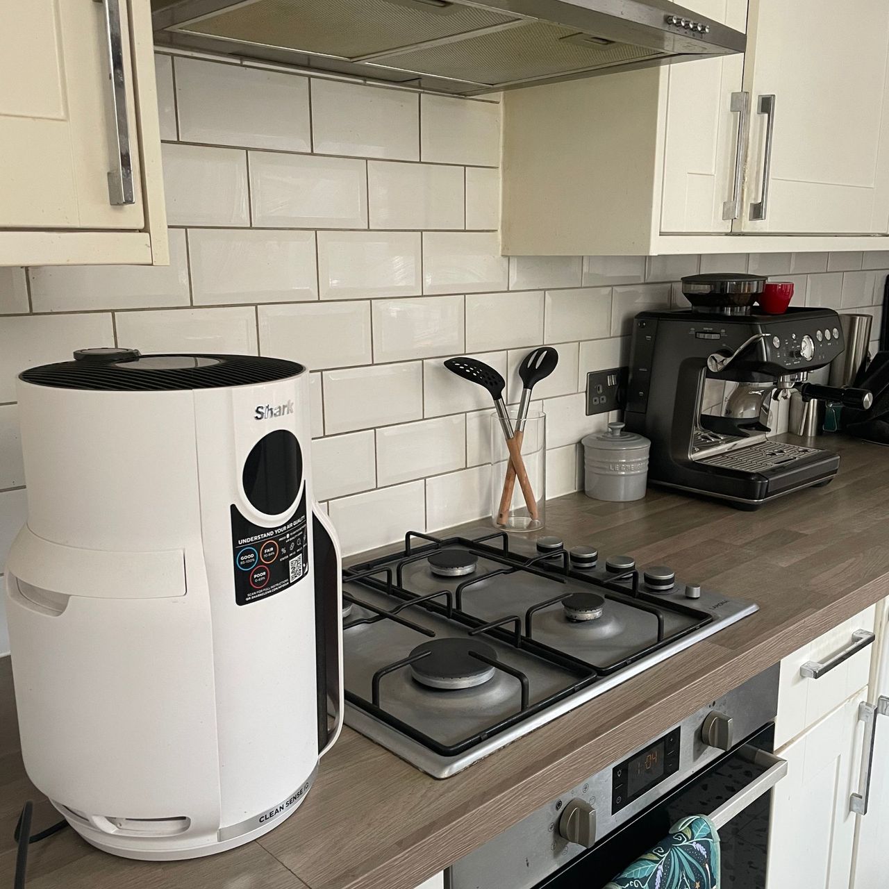 Shark NeverChange 5 Air Purifier sitting on a dark wooden kitchen worktop, next to a gas hob
