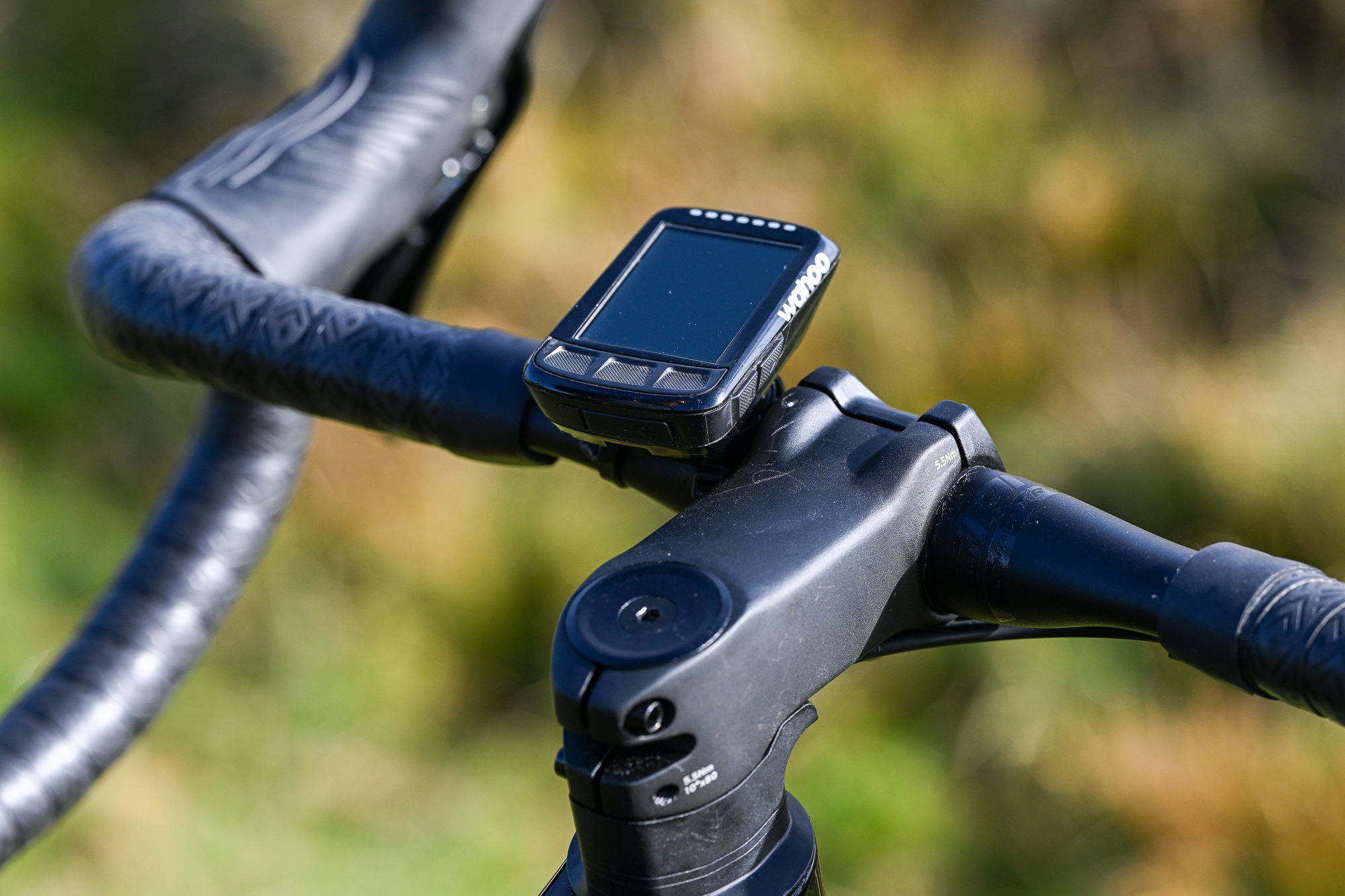close up of the stem and handlebars on a black bike showing the computer mounted on the bars