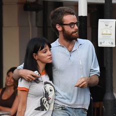 Lily Allen wearing a ringer tee, blue jeans, with sandals, and a black Birkin
