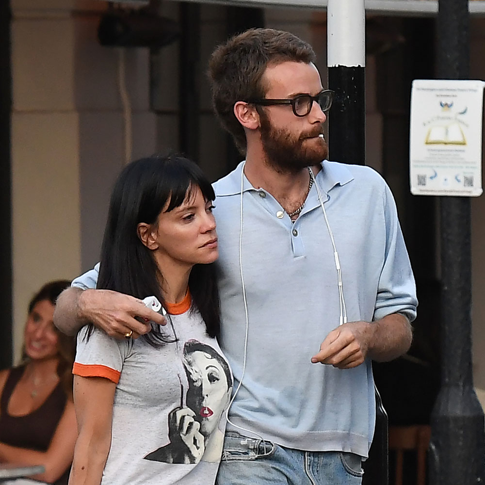 Lily Allen wearing a ringer tee, blue jeans, with sandals, and a black Birkin