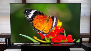 LG C3 OLED pöydällä näyttämässä oranssia perhosta