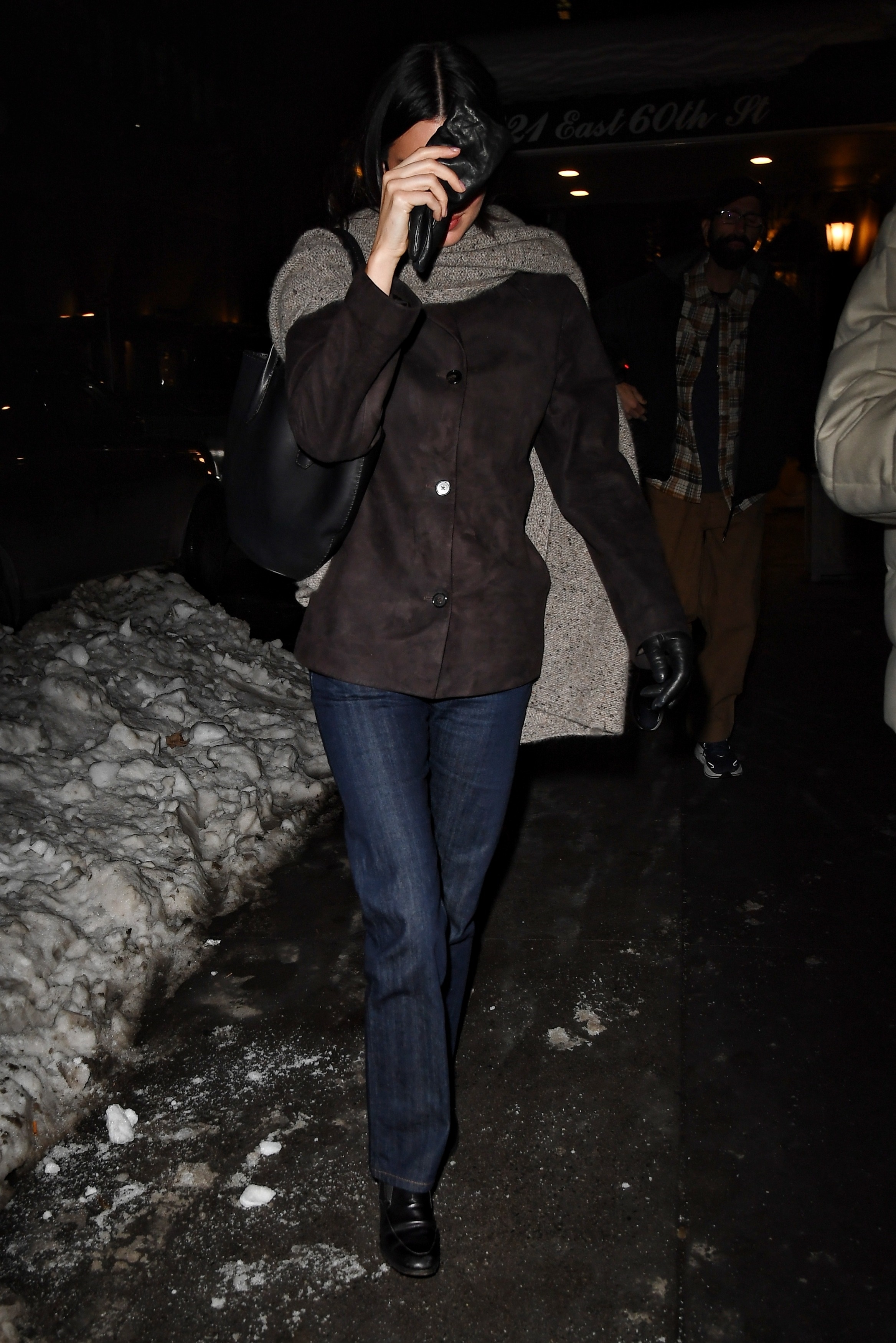 Kendall Jenner wears stove pipe jeans with a dark brown suede jacket and leather loafers.