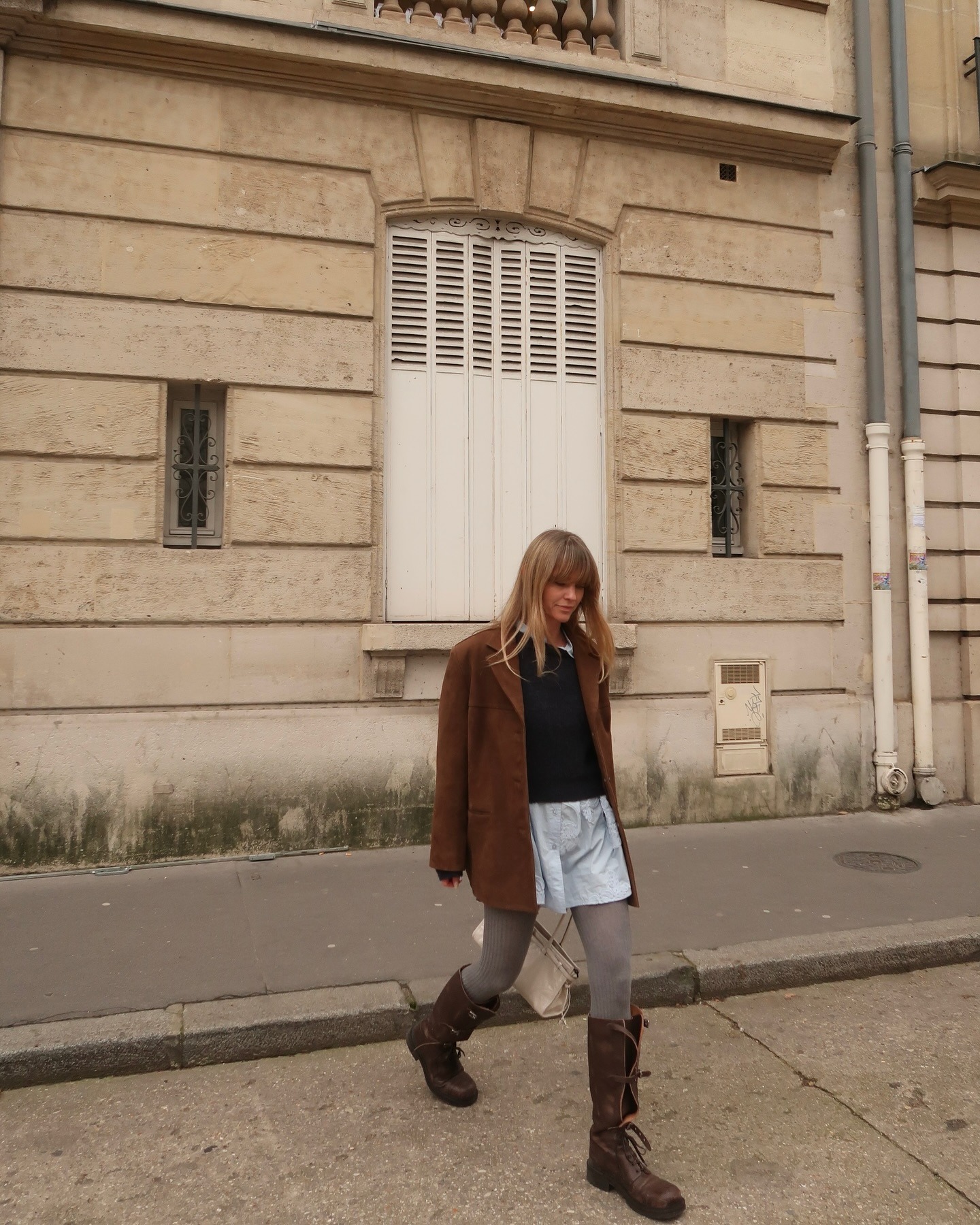 Influencer @_jeanettemadsen_ wears grey tights with brown knee-high boots and a suede jacket.