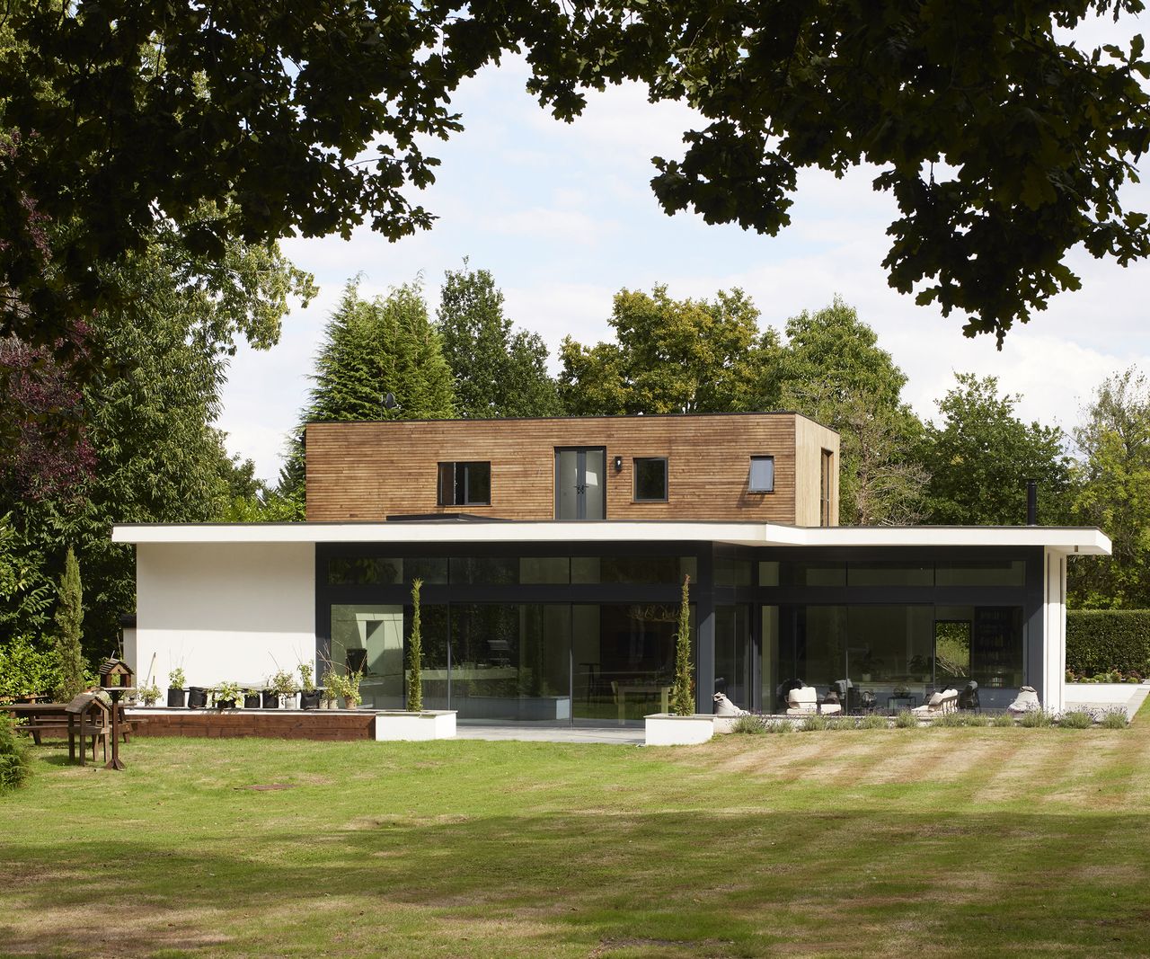 back view of a contemporary home self build with lawn and outdoor living area