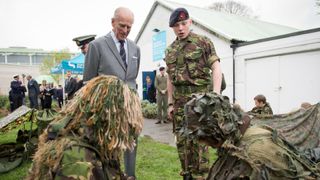 Britain's Prince Philip, Duke of Edinburgh (L back) meets cadets at the Windsor Sea Cadet Unit opening in Windsor, Berkshire, West of London, on April 7, 2014. The Sea Cadet Corps is a UK national youth organization sponsored by the Royal Navy and open to young people between the ages of 10-18 years old.