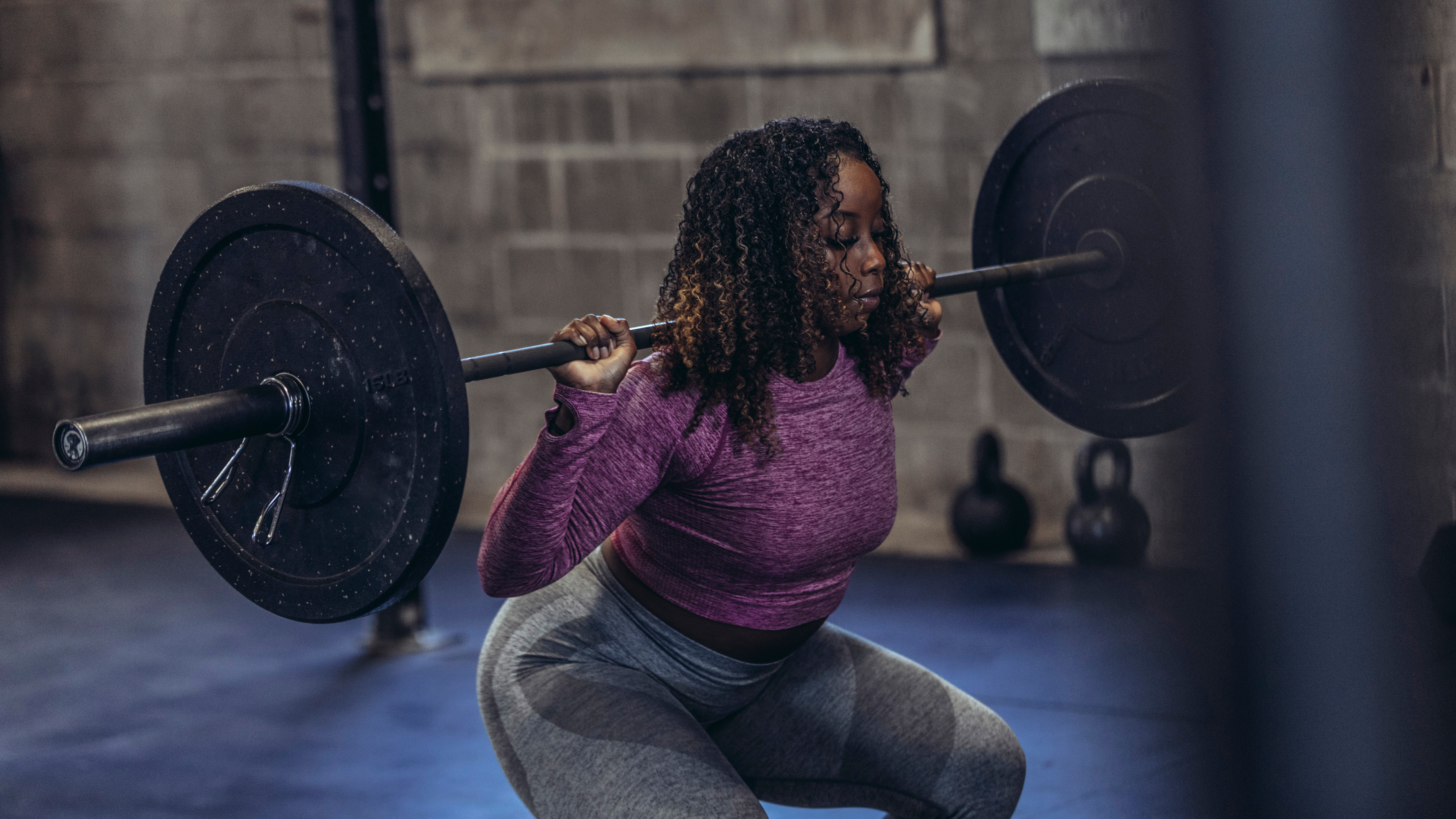 Woman performing squat with barbell