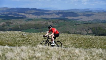 Male cyclist riding hard to increase his average speed