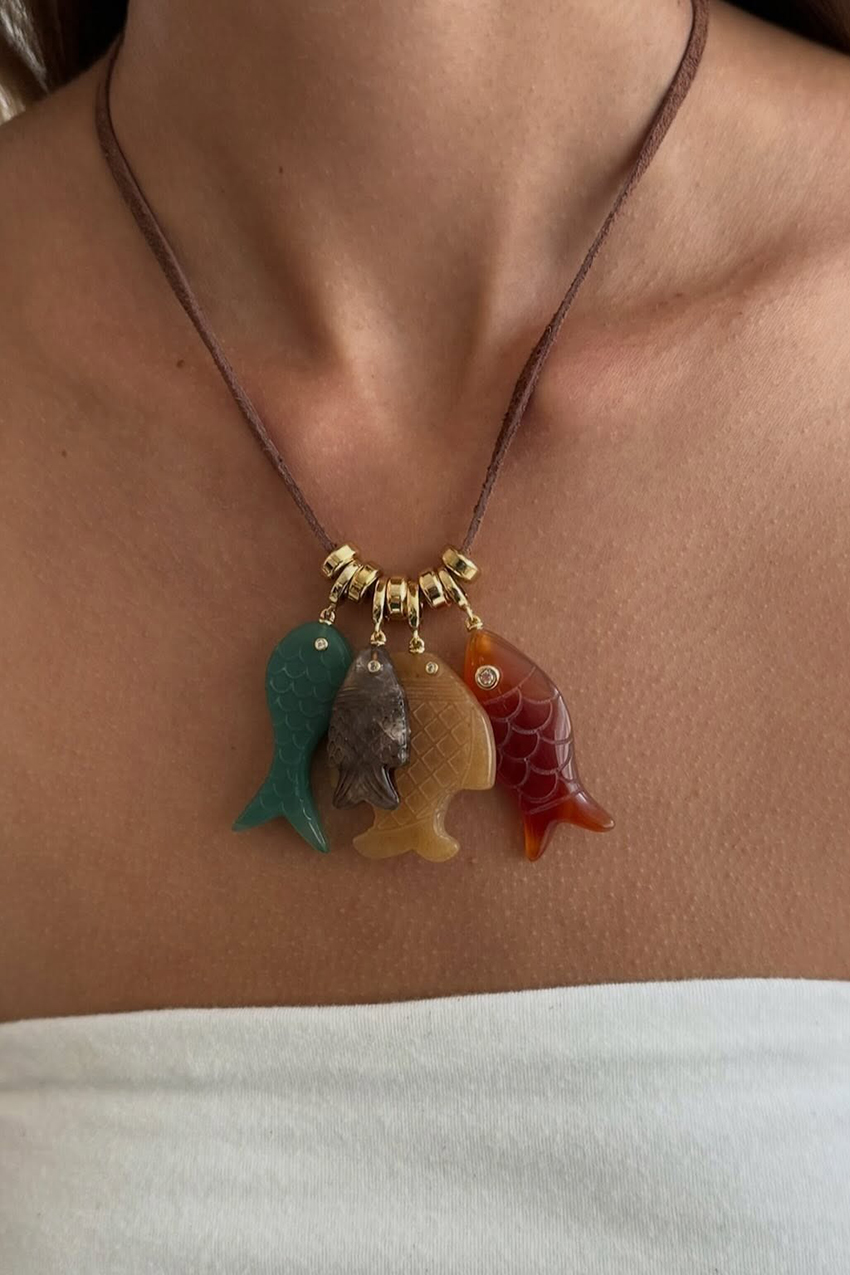 A woman wearing a fish charm necklace.