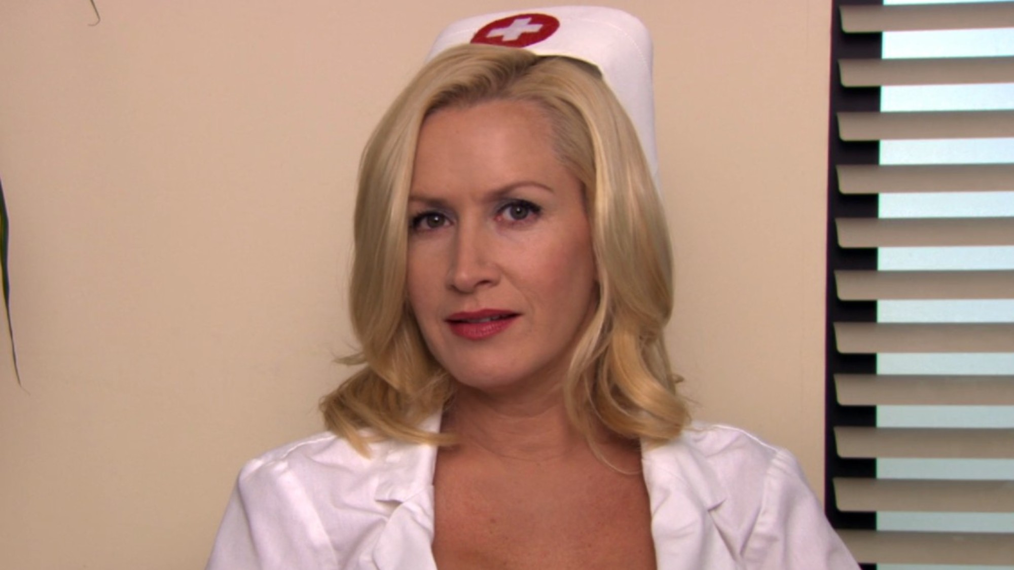 Angela Kinsey in a nurse outfit, being interviewed in the office.