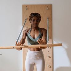 A woman doing some of the best wall Pilates exercises for core