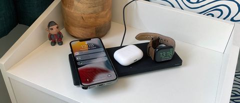 Belkin Boost Charge Pro 3-in-1 Wireless Charging Pad on a bedside table.