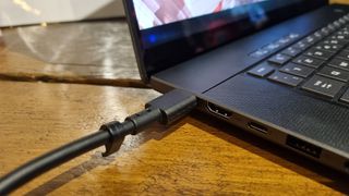 A charging cable plugged into an Asus Zephyrus G16 gaming laptop