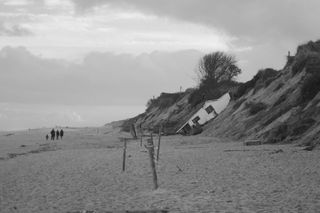 A home in Hemsby falling over a cliff onto the beach due to coastal erosion