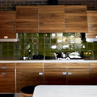 Kitchen with green tiles and wooden cabinet
