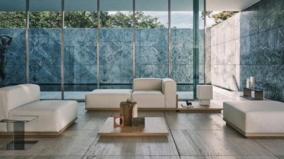 Vincent Van Duysen x Zara Home sleek side table, modular clean-lined seating, and a wooden low-rise coffee table with various objects resting atop, photographed in large glass-walled living room, which is flooded with natural light