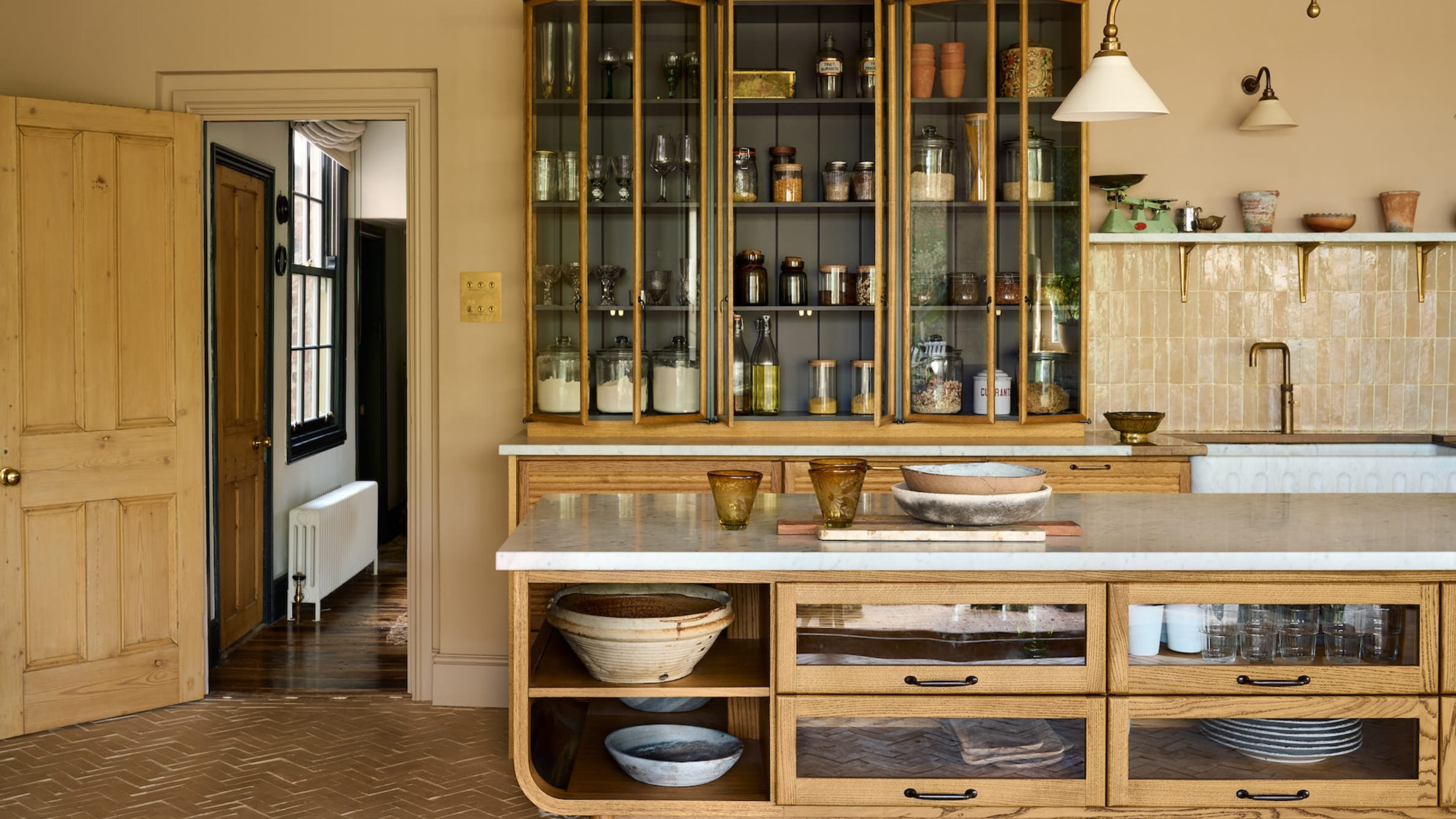 a kitchen island with glass fronted and open storage space 