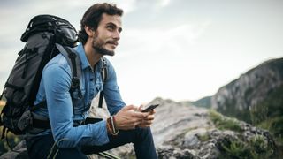 Man using navigation app on his phone while hiking