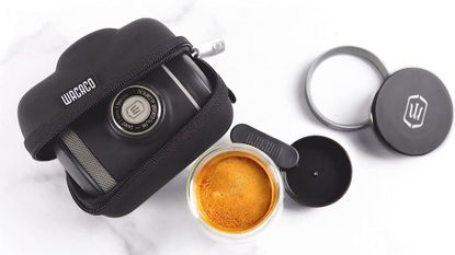 A Wacaco Picopresso on a marble countertop with a finished espresso and travel case