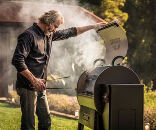person cooking on a large wood pellet smoker grill